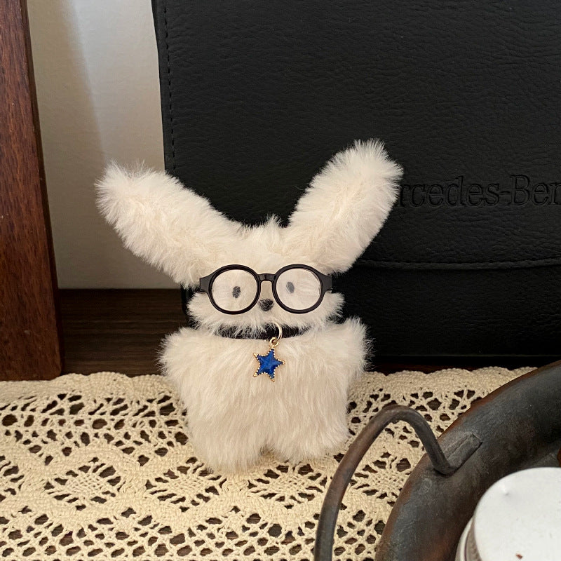 Glasses puppy plush toy with pendant standing on the ground