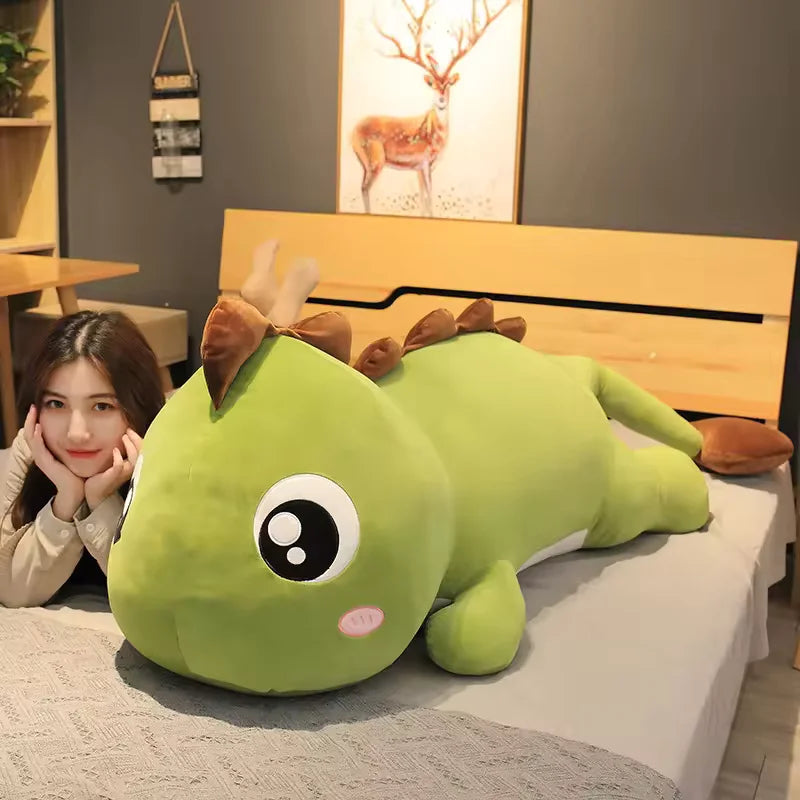 Dark green dinosaur pillow plush toy lying on the bed