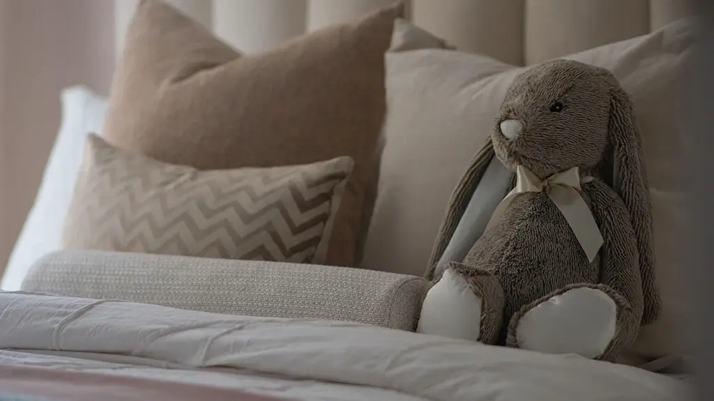 Comfortable bunny plush toy on the bed