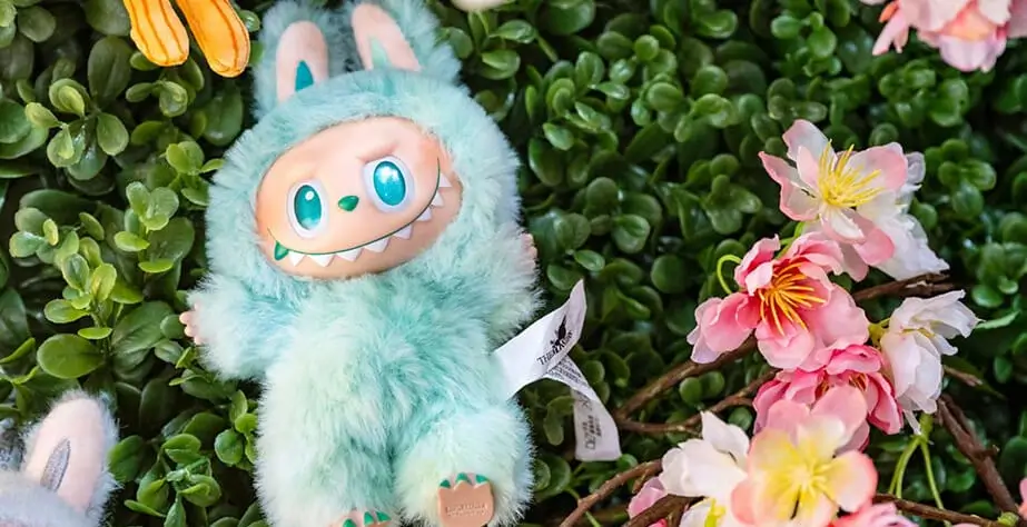 Πράσινο Labubu ξαπλωμένο στα λουλούδια